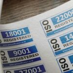 ISO certification stickers with registration numbers on paper.