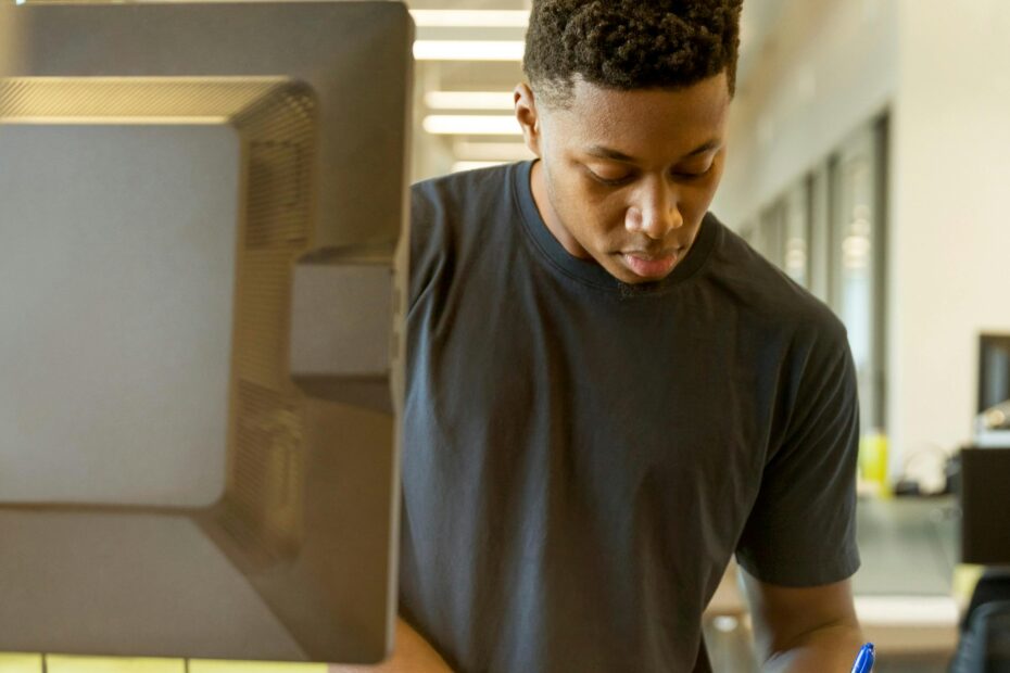 Young man intensely focused on his work at a modern tech office.