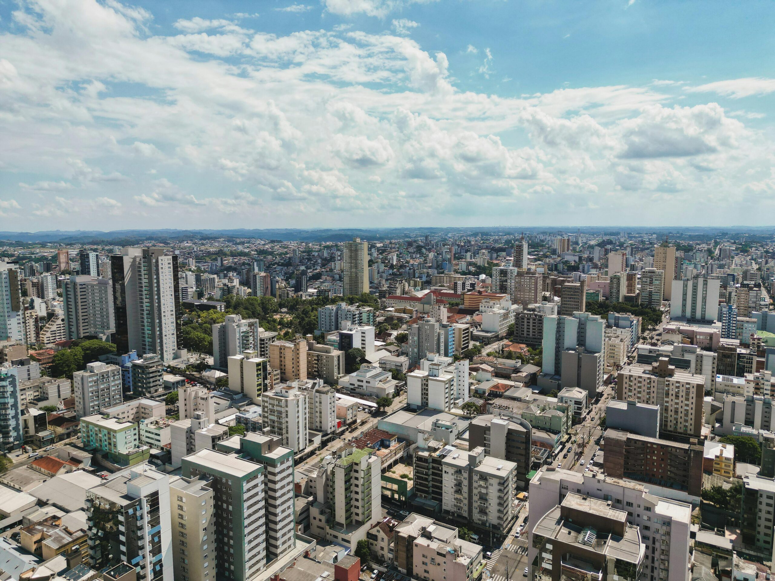 Stunning aerial view of Caxias do Sul showcasing modern buildings and sprawling urban landscape under a clear sky.